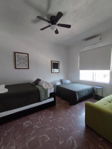 a bedroom with two beds and a ceiling fan at DGM Lofts MTY MN 960 D centro cerca de todo in Monterrey