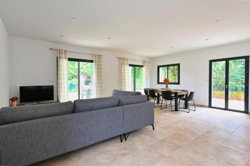 un salon avec un canapé et une table dans l'établissement Villa neuve climatisée, avec piscine - 15 mn d'Uzès et du Pont du Gard, à Blauzac