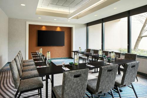 a conference room with tables and chairs and a flat screen tv at Washington Dulles Marriott Suites in Herndon