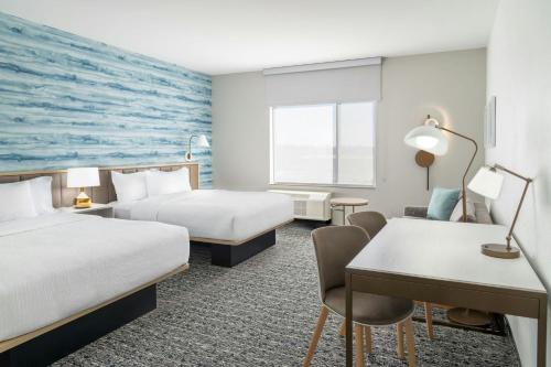 a hotel room with two beds and a desk at TownePlace Suites by Marriott Detroit Taylor in Taylor