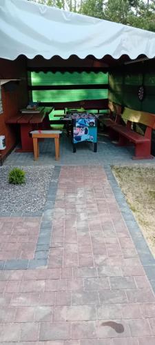 a picnic shelter with a table and a bench at Domki i pokoje ,,Pod Palmami" w centrum in Okuninka