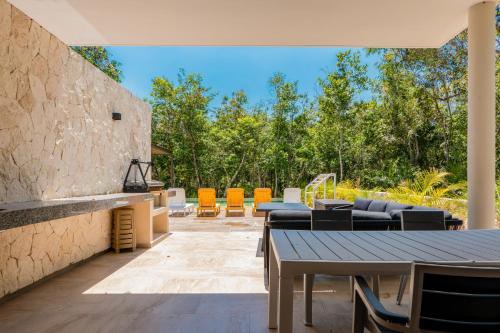 an outdoor patio with a table and chairs at Casa Jaguar in Xpu Ha