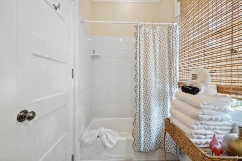 a bathroom with a shower and a stack of towels at 67 Wiggle Lane - Rosemary Beach - Steps to Tennis Courts, Beach, Pools! in Rosemary Beach