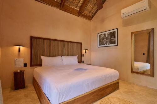 a bedroom with a large bed and a mirror at Pan Beach in Brisas de Zicatela