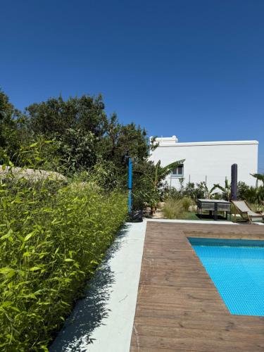 a swimming pool in front of a house at Minimal Cream Apartment Pool-front in Paros in Parikia