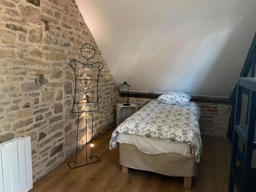クレシーにあるGîte de la Consoude - Clécyのベッドと壁にドレスが掛かっている部屋
