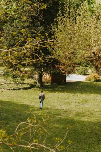 a man standing in the grass in a field at Maison d'hôtes et gîte de charme avec piscine, La Lhuiseraie in Lhuis