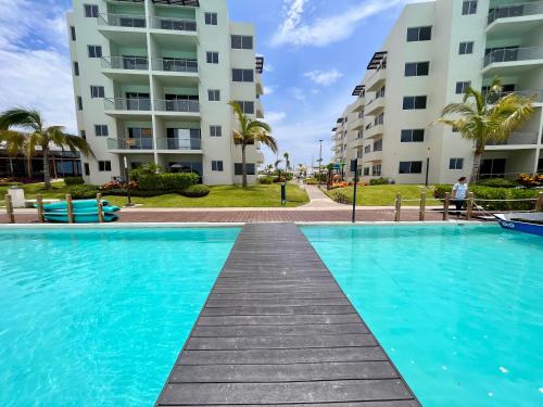 a swimming pool in front of two apartment buildings at Fantástico Depa en BLUU con PLAYA ARTIFICIAL - Turquesa 208 - in Mazatlán