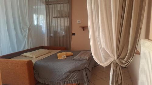 a small bed in a room with a curtain at B&B Picchio in Madonna di Fornelli