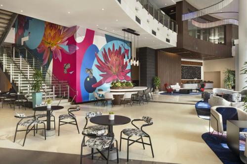 a lobby with tables and chairs and a colorful wall at Courtyard by Marriott Los Angeles L.A. LIVE in Los Angeles