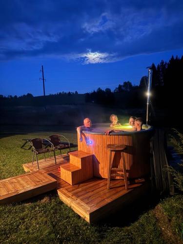 two children in a hot tub on a deck at Šnekučių kaimas in Miežonys
