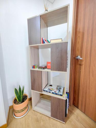 a book shelf in a room with a potted plant at Edificio Urban in Cajicá