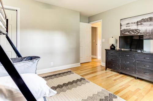 a bedroom with a bed and a dresser and a television at Newly Renovated Lake Bowen Home with Game Room! in Campobello