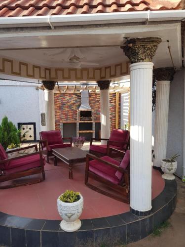 a covered patio with chairs and a table at The Manor in Lomé