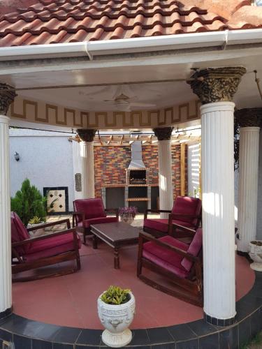 a patio with red chairs and a table on a house at The Manor in Lomé