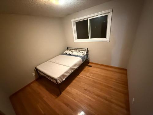 a small bedroom with a bed and a window at Homestay at Heart Of Kitchener-Free Wifi & Parking in Kitchener