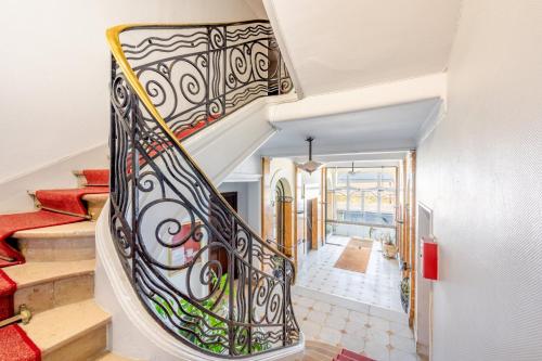 un escalier avec une rampe en fer forgé dans une maison dans l'établissement La Suite des Sables, à Houlgate