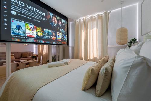 - une chambre avec une grande télévision murale dans l'établissement La Suite des Sables, à Houlgate