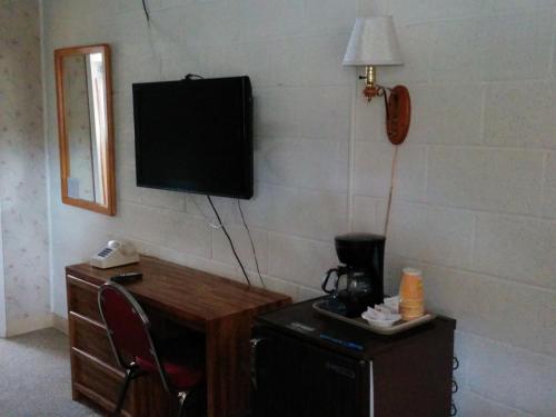 a room with a television and a desk with a chair at Starlight Motel in Big Pine