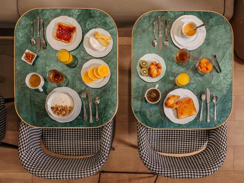 a green table with breakfast foods on it at Hôtel Zélie in Paris