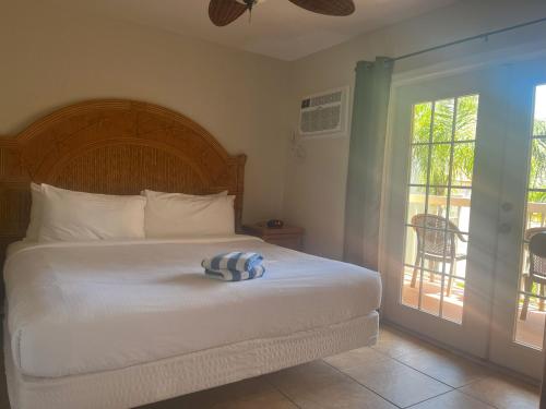 a bedroom with a bed and a sliding glass door at Beso Del Sol Resort in Dunedin