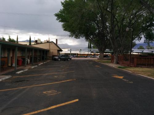an empty parking lot with a car parked in it at Starlight Motel in Big Pine