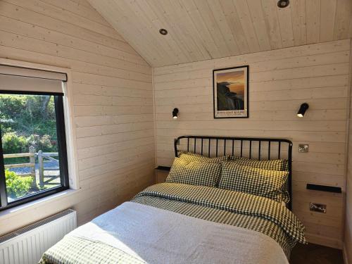 a bed in a small room with a window at Briarfield Farm Stays - Coillte Cabin in Glenarm