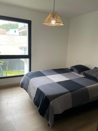 une chambre avec un lit et une grande fenêtre dans l'établissement Villa Foch, à Cenon