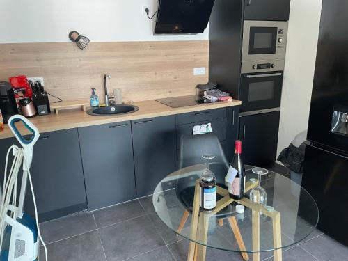 une petite cuisine avec une table en verre et un évier dans l'établissement Villa Foch, à Cenon