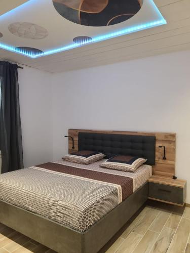 - une chambre dotée d'un lit avec une lumière bleue au-dessus dans l'établissement Gîte Lou Galoubet, à Saint-Étienne-du-Grès