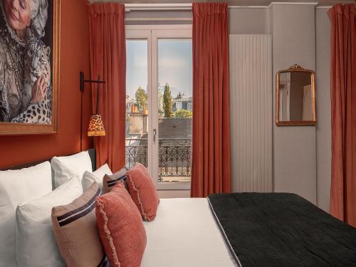 a hotel room with a bed and a window at Hôtel Zélie in Paris