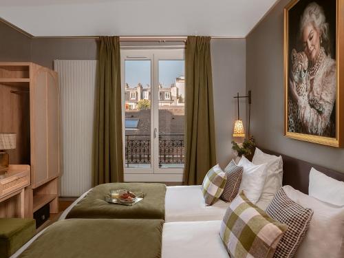 a hotel room with a bed and a window at Hôtel Zélie in Paris