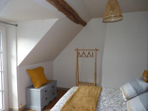 a attic bedroom with a bed and a mirror at La maison d'à côté in Montigny-sur-Loing