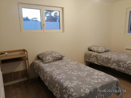 une chambre avec deux lits et une table et deux fenêtres dans l'établissement Villa 4 chambres, à Montblanc