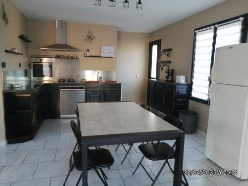 une cuisine avec une table, des chaises et un réfrigérateur dans l'établissement Villa 4 chambres, à Montblanc