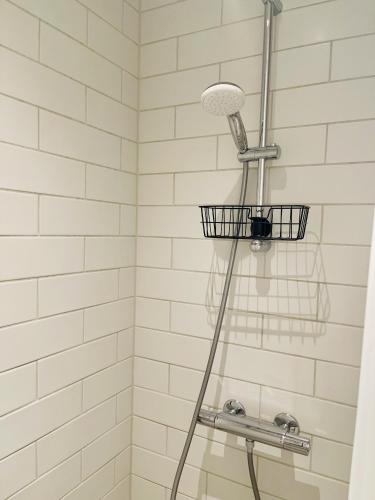 a shower with a shower head and a basket at Nuuk Stay in Nuuk