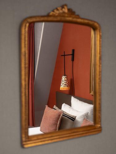 a mirror reflection of a bed in a room at Hôtel Zélie in Paris
