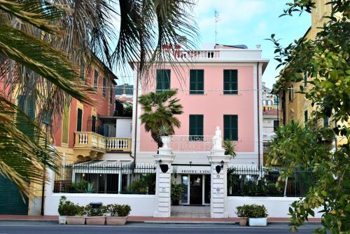 a pink building on a street with palm trees at Hotel Lido in Varazze