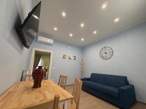 a living room with a table and a blue couch at Don Mimì Casa Vacanza in Torre del Greco