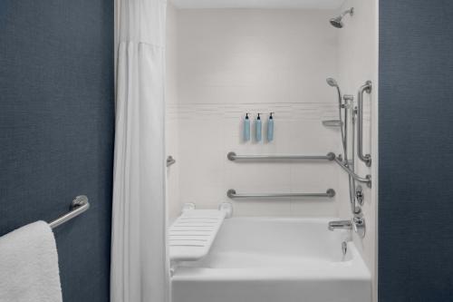 a bathroom with a white bath tub and towel racks at Residence Inn Salt Lake City Murray in Murray