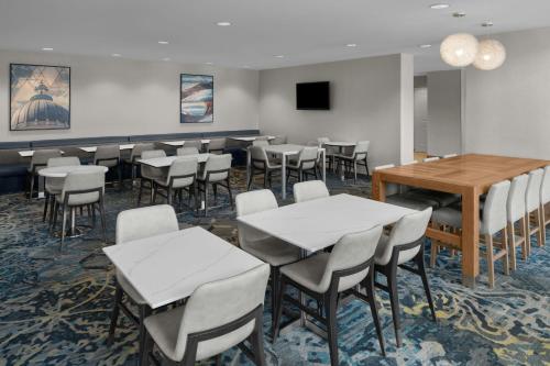 a dining room with tables and chairs and a tv at Residence Inn Salt Lake City Murray in Murray