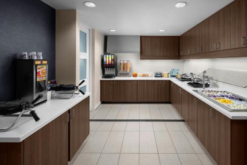 a large kitchen with wooden cabinets and a refrigerator at Residence Inn Salt Lake City Murray in Murray