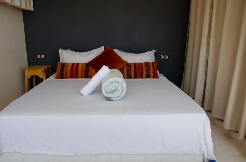a bedroom with a white bed with a towel on it at SurfAppart Morocco in Tamraght Ouzdar