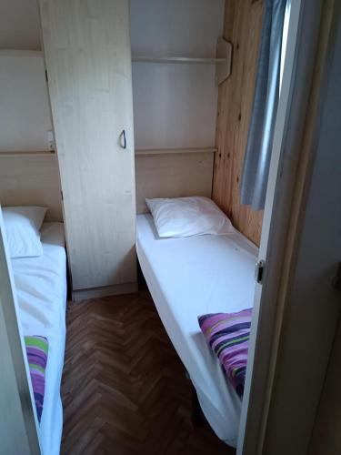 Cette petite chambre comprend 2 lits. dans l'établissement Camping Les Embruns N2, au Grau-dʼAgde