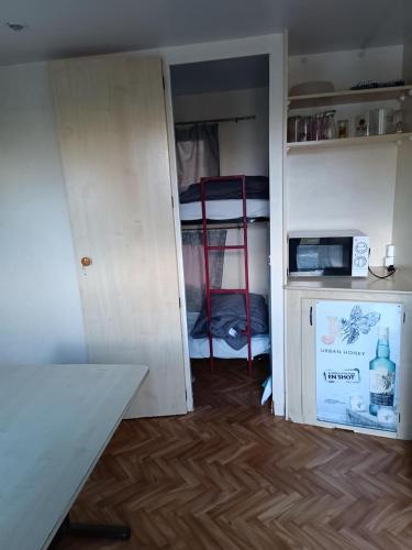 Cette petite chambre dispose d'une armoire et d'un four micro-ondes. dans l'établissement Camping Les Embruns N2, au Grau-dʼAgde