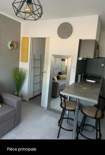 une cuisine et un salon avec une table et des chaises dans l'établissement Studio les Sablettes vue mer, à La Seyne-sur-Mer