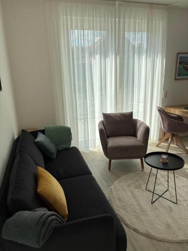 a living room with a couch and a chair at Appartement Löwenzahn in Spangenberg