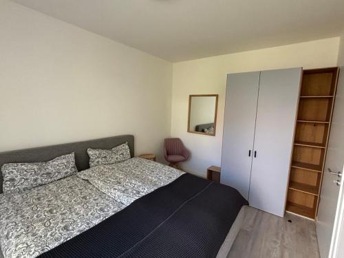 a bedroom with a bed and a white cabinet at Appartement Löwenzahn in Spangenberg