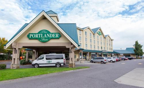 The Portlander Inn and Marketplace في بورتلاند: مبنى به سيارة متوقفة في موقف للسيارات