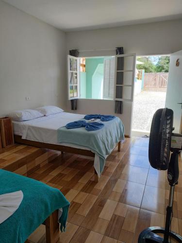 a bedroom with a bed and a mirror and a camera at Suites Vitasha - Ubatumirim in Ubatuba